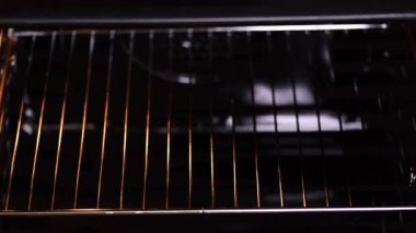 Genç kadın elleri kek kalıplarını fırına koyuyor..