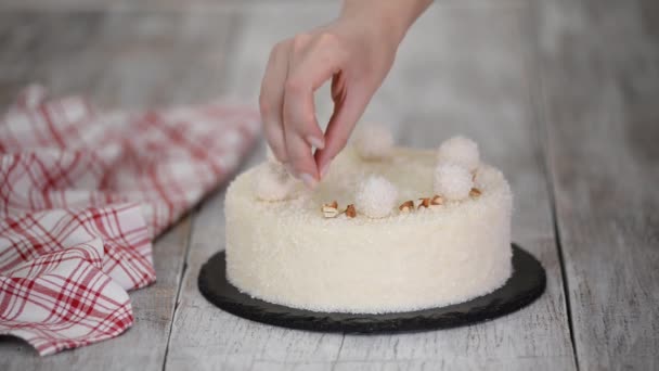 Le mani femminili cospargono la torta di mousse di cocco con mandorle. Alimenti dolci. — Video Stock