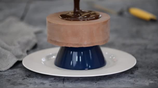 Pasticcere che decorano una torta di mousse con smalto a specchio al cioccolato. Il processo di preparazione del dessert in cucina. — Video Stock