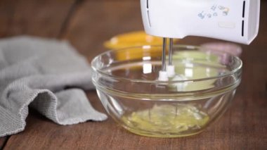Bir cam kasede yumurta beyazı karıştırıcı ile dövmek.