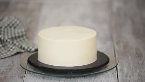 Pastel de crema blanca casera en un soporte giratorio en una cocina casera. — Vídeos de Stock