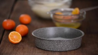 Kadın mutfakta mandalina keki pişiriyor..