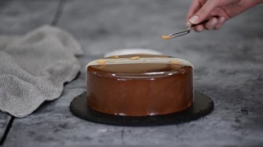 Pasta şeflerinin elleri kremalı pastayı fıstıkla süslüyor..