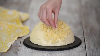 Kadın ananaslı geleneksel mimoza keki yapıyor..