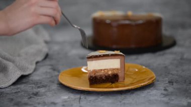 Bir parça çikolatalı, karamelli, fıstıklı, kremalı pasta, tabakta snickers..