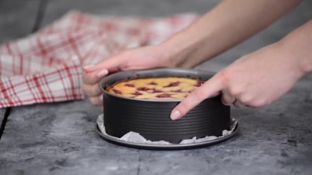 Närbild av händerna på en kvinna som tar bort mögel från cheesecake. — Stockvideo