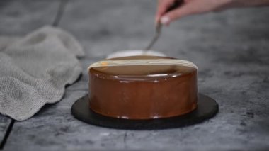 Pasta şeflerinin elleri kremalı pastayı fıstıkla süslüyor..