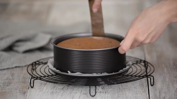 Vrouw haalt chocoladecake uit de schimmel op tafel. — Stockvideo