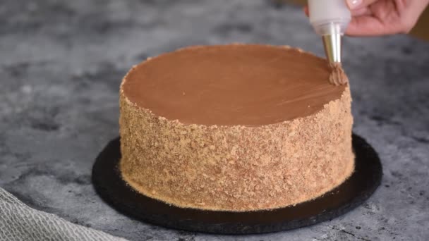Gâteau de décoration femme avec crème au chocolat tenant sac à pâtisserie dans la cuisine. — Video
