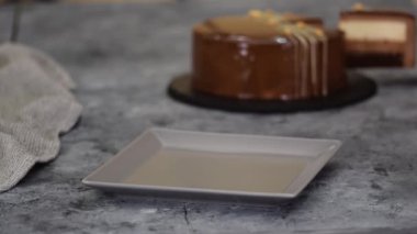 Bir parça çikolatalı, karamelli, fıstıklı, kremalı pasta, tabakta snickers..