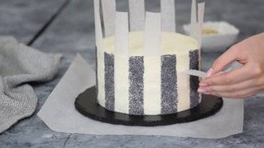 Tanınmayan kadın pasta şefi haşhaş tohumlarıyla pasta süslüyor..