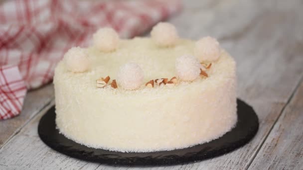 As mãos femininas polvilhe o bolo de mousse de coco com amêndoas. Comida doce. — Vídeo de Stock