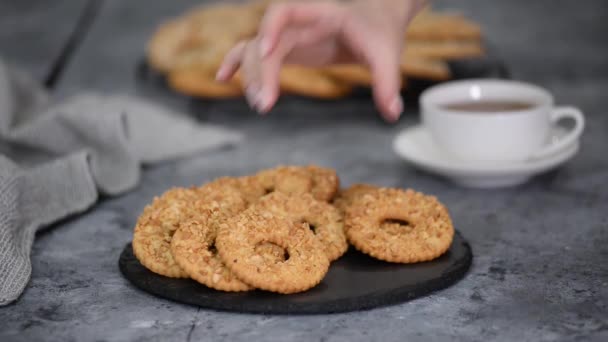 Печенье с арахисом и чашкой чая на деревянном столе. — стоковое видео