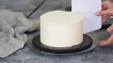 Şef pastayı kremayla kaplıyor..