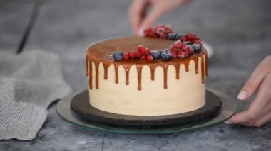Pasta şefi karamel kekini donmuş yaz meyveleriyle süslüyor..