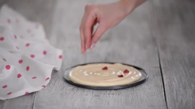 Pasta şefi elleri pasta hamuruna donmuş ahududu serpiyor..