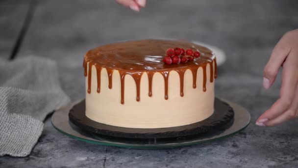 Chef pâtissier décorer gâteau au caramel avec des baies d'été congelées. — Video