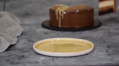 Bir parça çikolatalı, karamelli, fıstıklı, kremalı pasta, tabakta snickers..