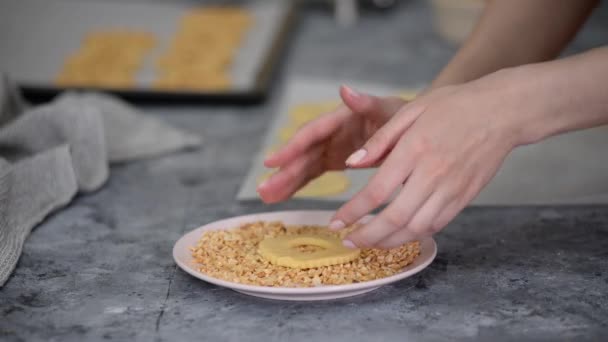 A nő kerek mogyorós sütit készít apróra vágott mogyoróval megszórva.. — Stock videók