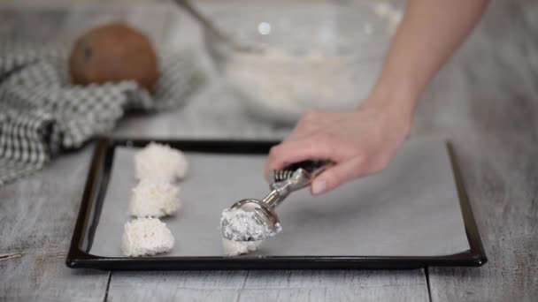 Kvinna förbereder kakor i köket, gör kokos makaroner. — Stockvideo