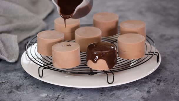 Bakverk kock häller spegel glasyr på choklad mousse kakor. — Stockvideo