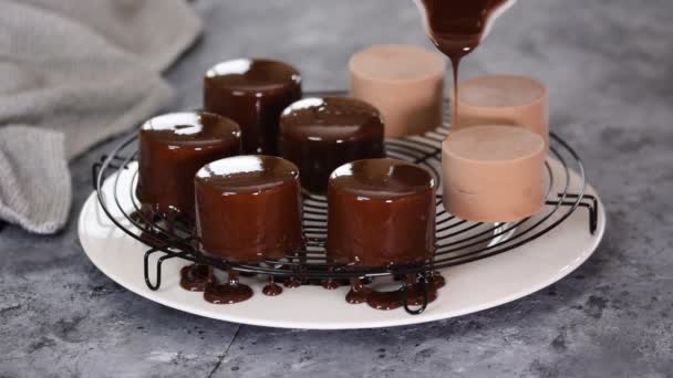 Chef pâtissier verse glaçure miroir sur les gâteaux de mousse au chocolat. — Video