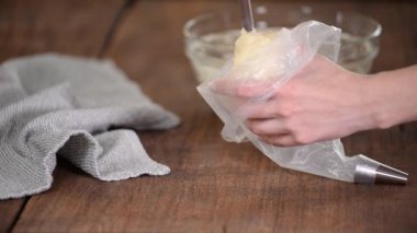 Bir kadın hamur torbasına hamur işi koyar..