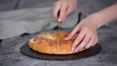 Şef lezzetli Khachapuri 'yi parçalara ayırdı.