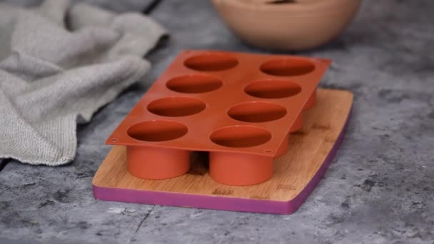Verser de la mousse au chocolat dans des moules en silicone. — Video