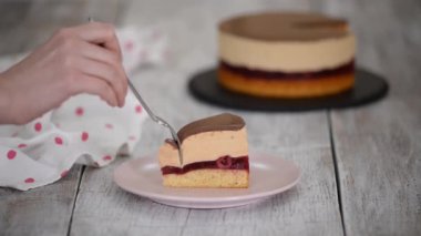 Karamelli kremalı vişneli pasta yiyen bir kadın..