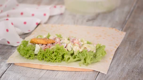 Mujer está cocinando pan de pita rollo con pollo y verduras. — Vídeos de Stock