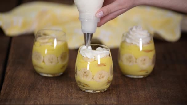 Bakverk kock dekorerade en banan pudding med vispgrädde. — Stockvideo