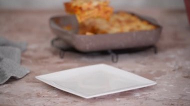 Lezzetli geleneksel İtalyan lazanyası. Beyaz tabakta bir parça lazanya..