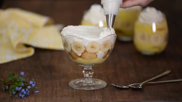 Bakverk kock dekorerade en banan pudding med vispgrädde. — Stockvideo
