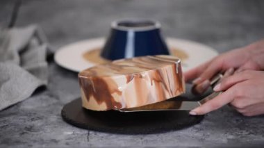 Bir pasta şefi aynalı kremalı kek yapar..