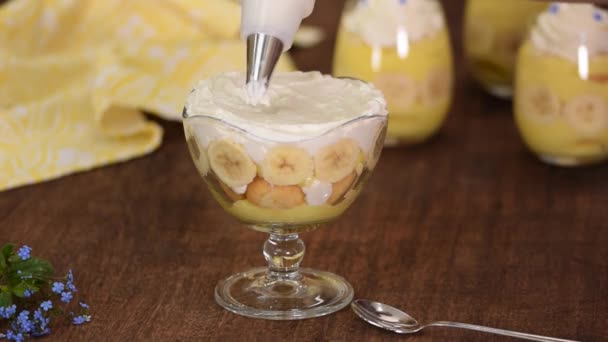 Pastry chef decorated a banana pudding with whipping cream. — Stock Video