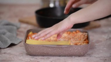 Kadın mutfakta katmanlı lazanya yapıyor. İtalyan yemeği..