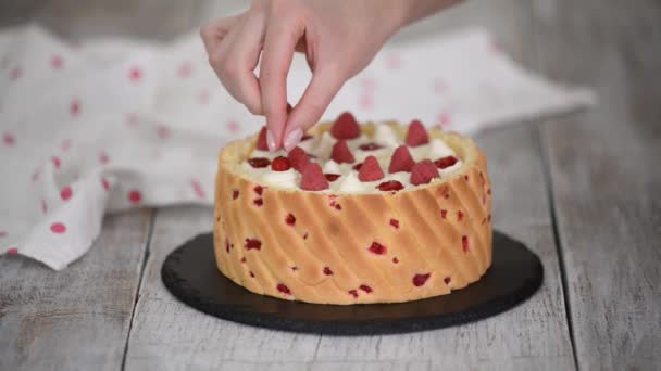 Шеф-повар украшает торт из мусса ягодами. — стоковое видео
