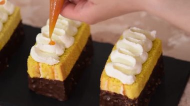 Kadın elleri pastadan kayısı reçeli ile sünger kekleri süsler..