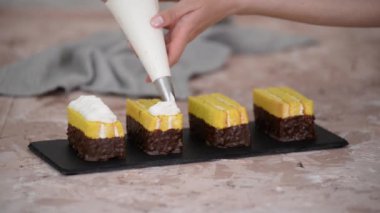 Kadın eli, sünger keki bir pasta torbasından çıkan kremayla süslüyor..