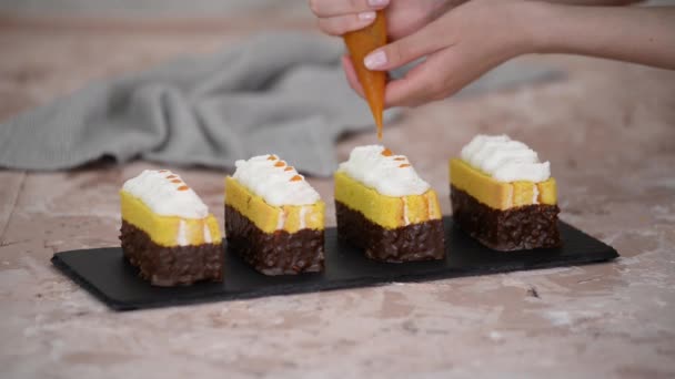 Női kéz díszíteni egy szivacs sütemények sárgabarack lekvár egy cukrász zsák. — Stock videók