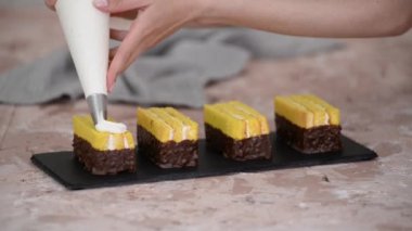 Kadın eli, sünger keki bir pasta torbasından çıkan kremayla süslüyor..