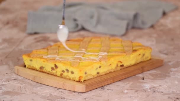 Verser la glaçure de sucre sur le gâteau traditionnel polonais sernik avec des raisins secs. — Video