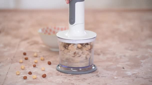 A Woman Chopping Almonds And Hazelnuts In A Food Processor. — Stock Video