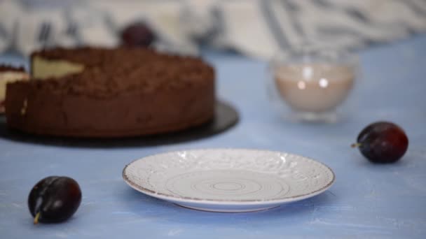 Pedaço de delicioso cheesecake caseiro com ameixas e chocolate crumble. — Vídeo de Stock