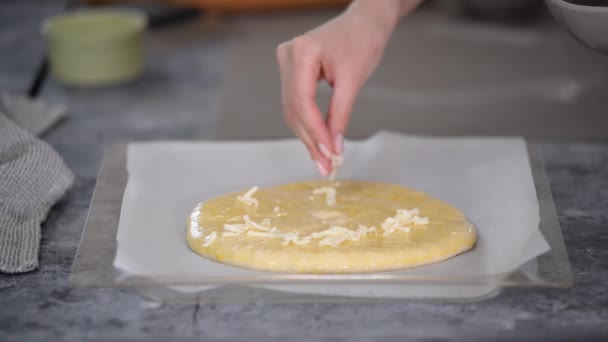 女性の手は カチャプリを作るためのチーズと生地を振りかける — ストック動画