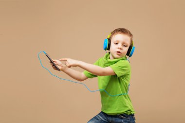 Mp3 Çalar tutan kulaklık yakışıklı küçük şık çocuk ve