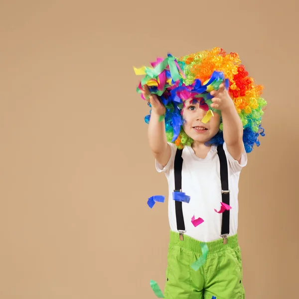 Lycklig clown pojke med stora färgglada peruk — Stockfoto
