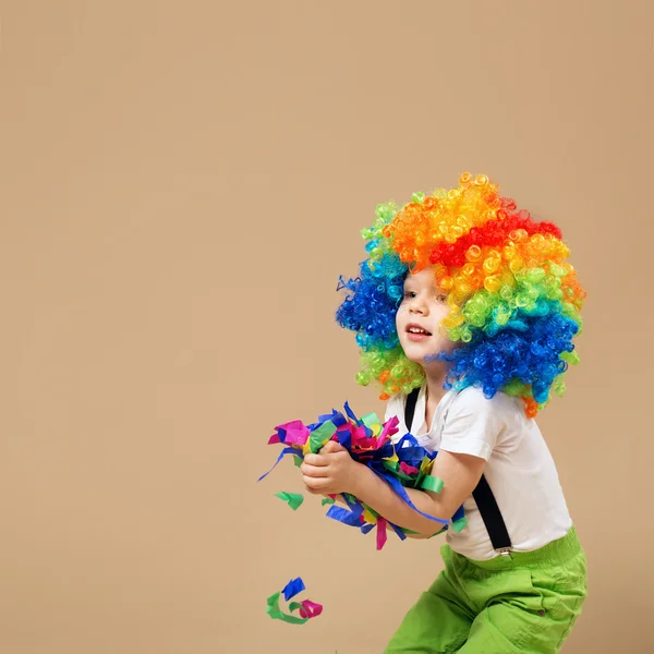 Niño payaso feliz con gran peluca colorida . —  Fotos de Stock