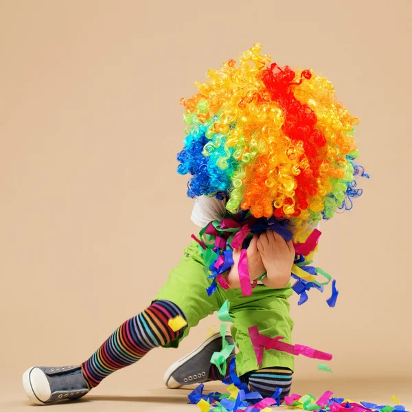 Felice clown ragazzo con grande parrucca colorata . — Foto Stock